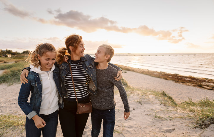 woman with MS walking on the beach with children