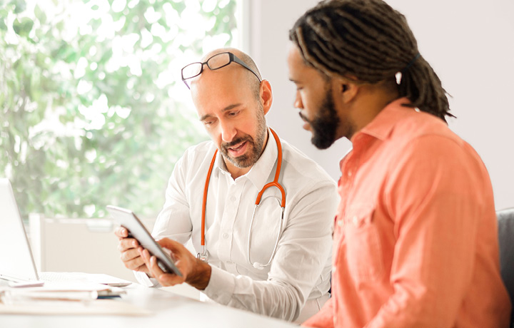 Doctor and patient discuss test results in office setting. 