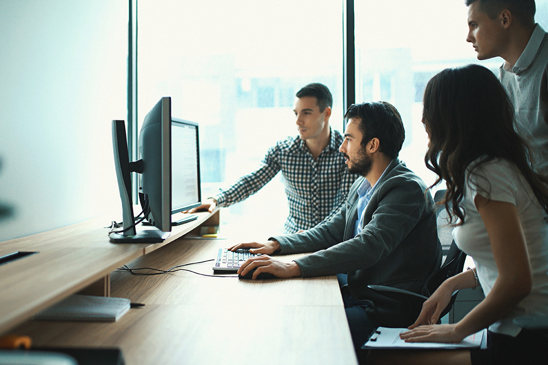 Team works on computer in office